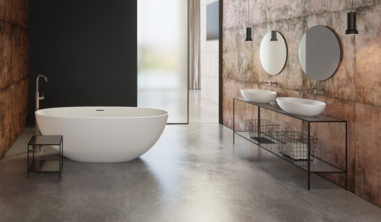 Industrial bathroom with an oval bathtub and double basin setup, representing stylish fixtures offered by a sanitary ware manufacturer.